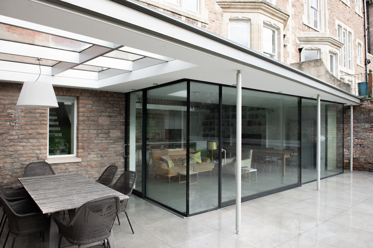 Modern glass extension with over-sailing roof