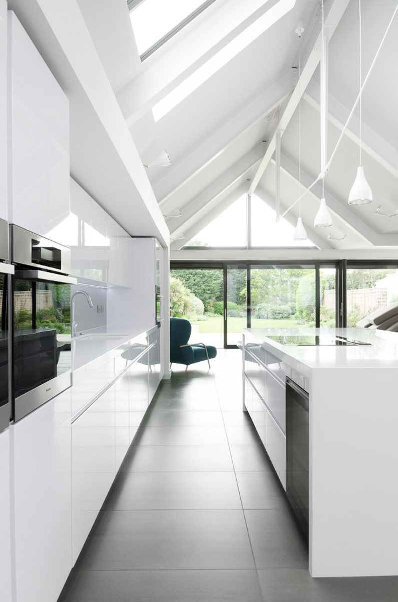 Vaulted white kitchen with garden views