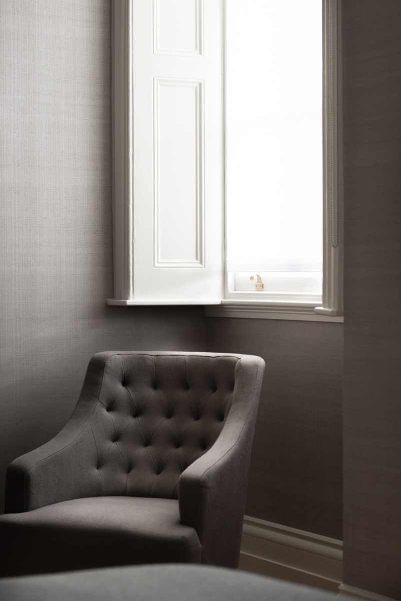 Textured grey fabric wallpaper and armchair