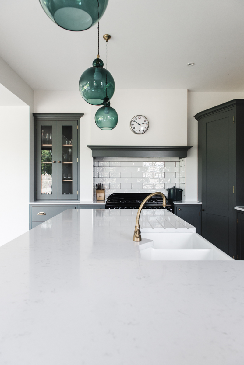 White kitchen island with sink and brass tap