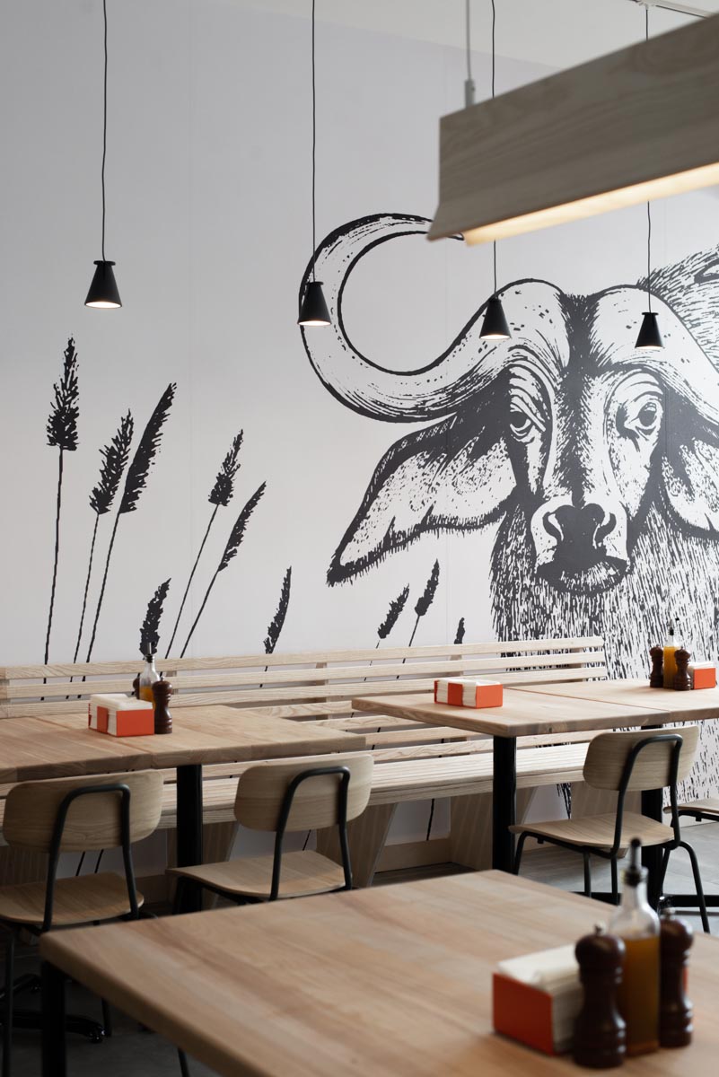 Pizza restaurant seating with bull wall mural