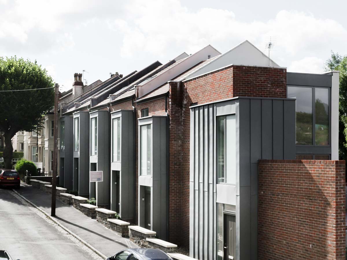 Stepped terrace houses in brick with zinc bays