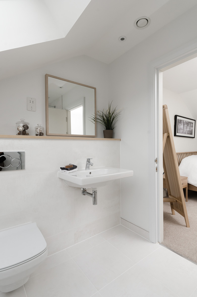 White ensuite bathroom with back to wall toilet and sink